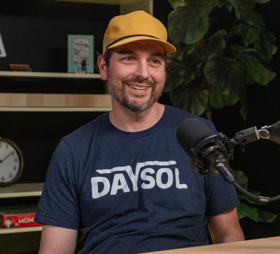 Burt Davis wearing a DaySol Coffee shirt speaking into a microphone during a podcast interview on The Localist.