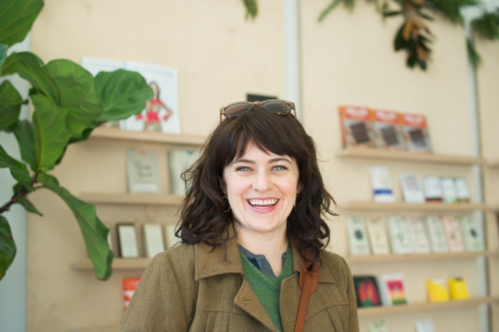 carrie rollwagen smiles at the camera in a local shop