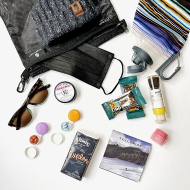 pouch holding ski supplies like granola bars, kleenex, laneige, trail map and sunglasses