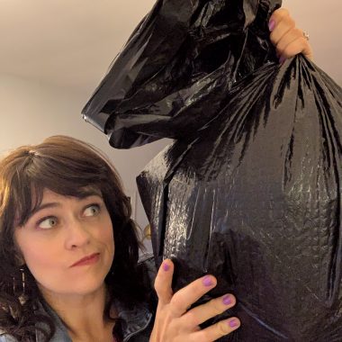 girl holding trash bag
