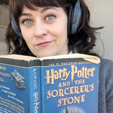girl reading harry potter with headphones
