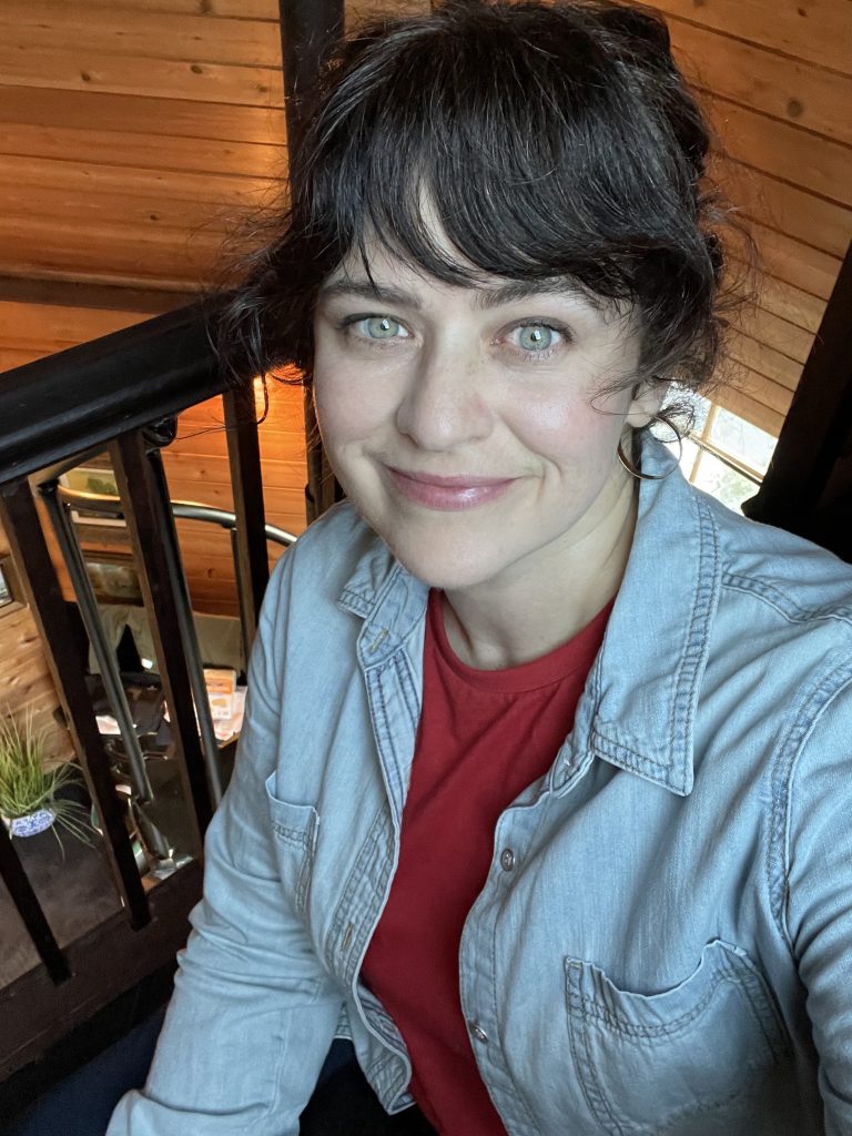 carrie rollwagen smiles at the camera in the tower room at the spanish consulate airbnb
