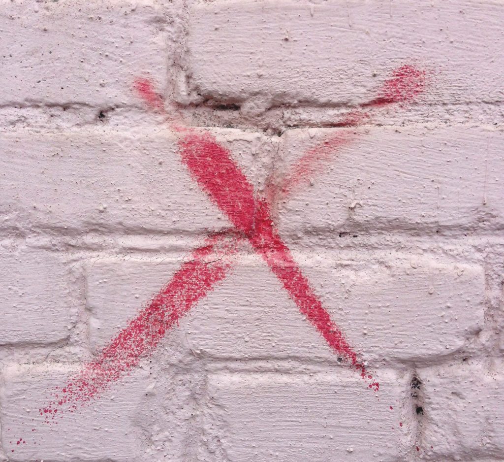 x painted on a brick wall